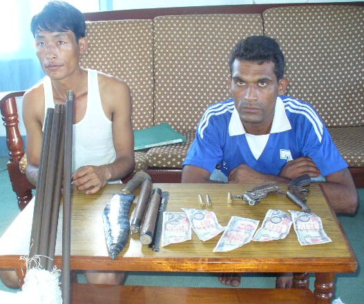 Bibek Limbu (right) and Prem Bista with seized weapons and fake notes